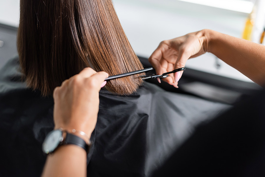 hairdo, croped view of hairdresser cutting short brunette hair of female client, holding scissors and comb, professional, beauty worker, haircut, salon job, salon customer